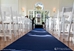 navy blue aisle runner with white chairs